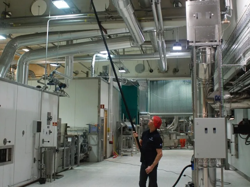 SpaceVac höghöjdsstädning av rör och ventilation i livsmedelsfabrik med kolfiberrör från golvet