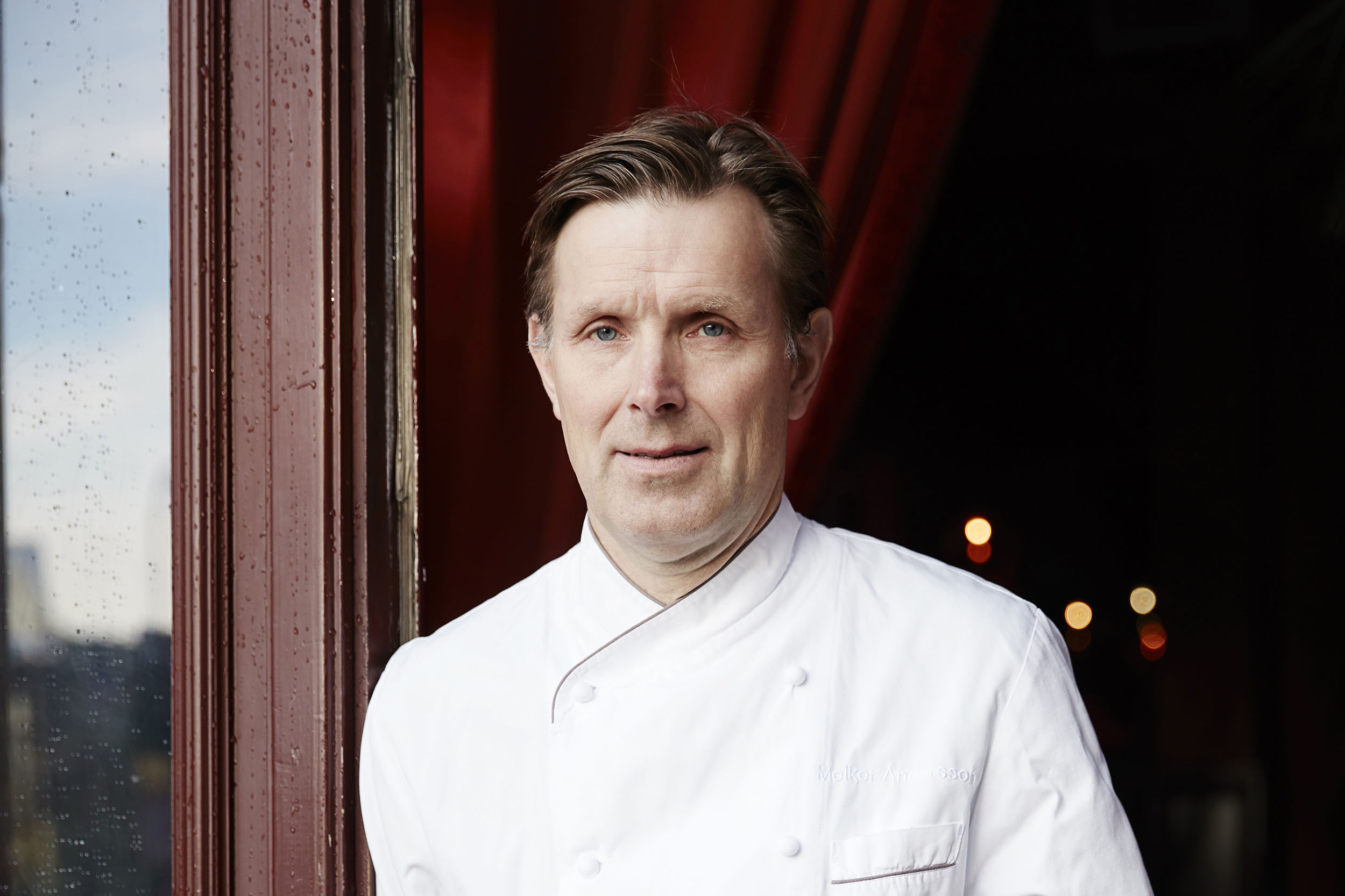 Porträttbild på kocken Melker Andersson i dörren till en av sina krogar.